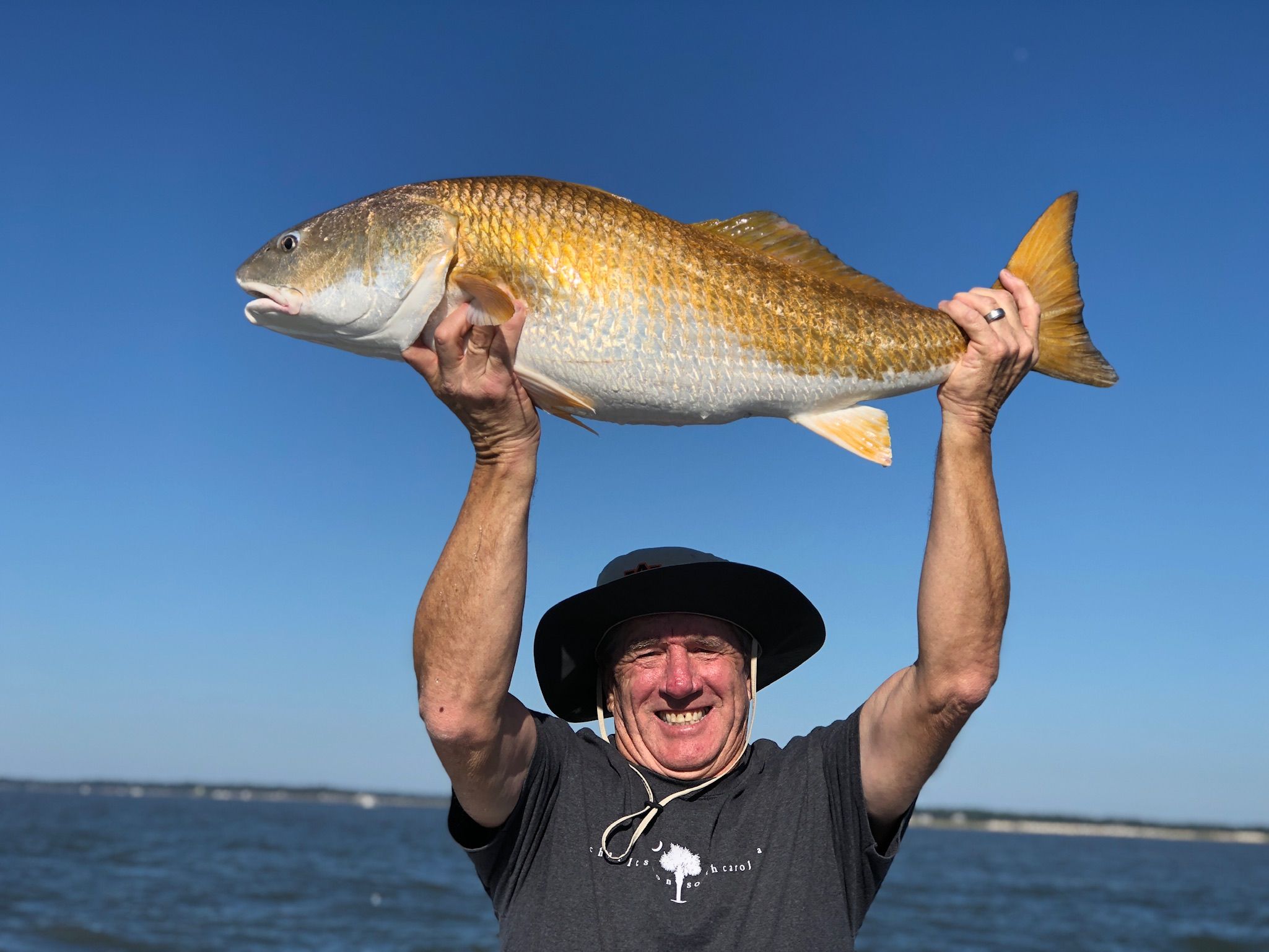 Angler holding a redfish overhead on a Hilton Head charter